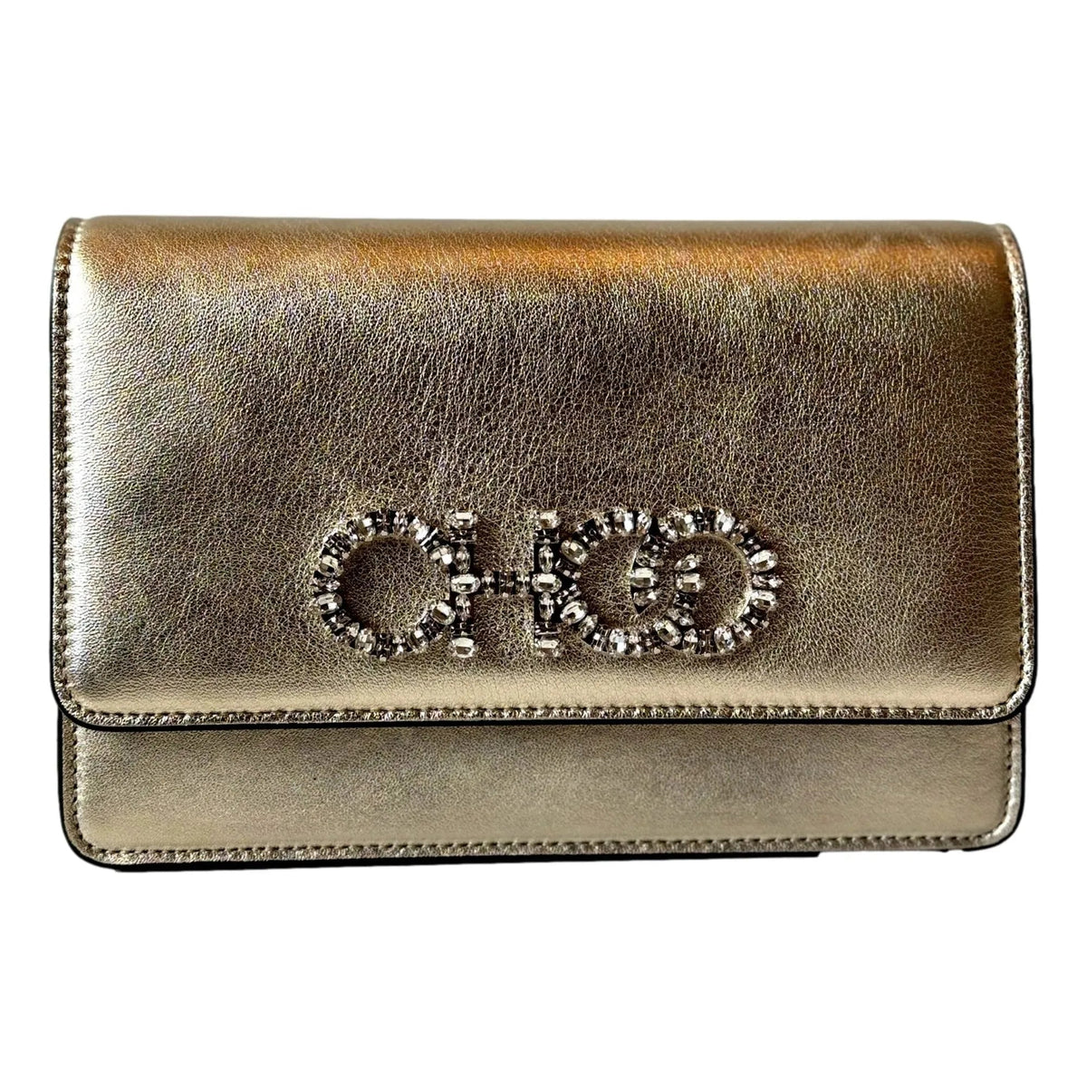 Jimmy Choo Kalina Crossbody Clutch Bag. Crafted from shimmering Metallic Gold Leather, adorned with the iconic Crystal Logo.